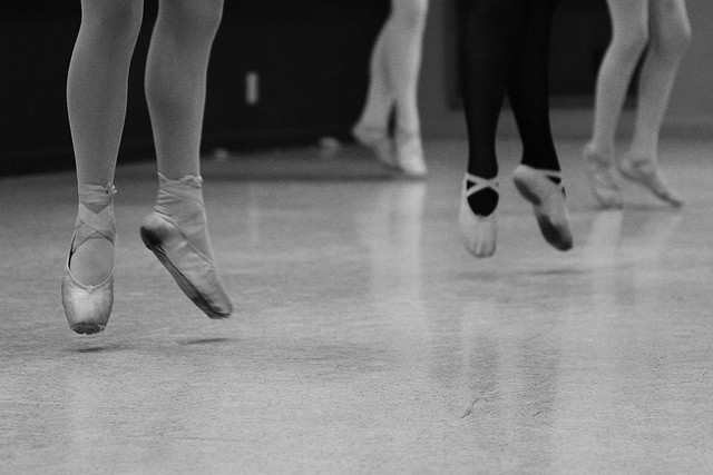 Jambes de danseuses en pleine action avec collants et pointes.