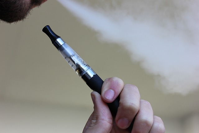 Homme utilisant une cigarette électronique.