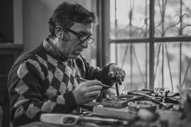 Senior en train de bricoler dans son atelier.
