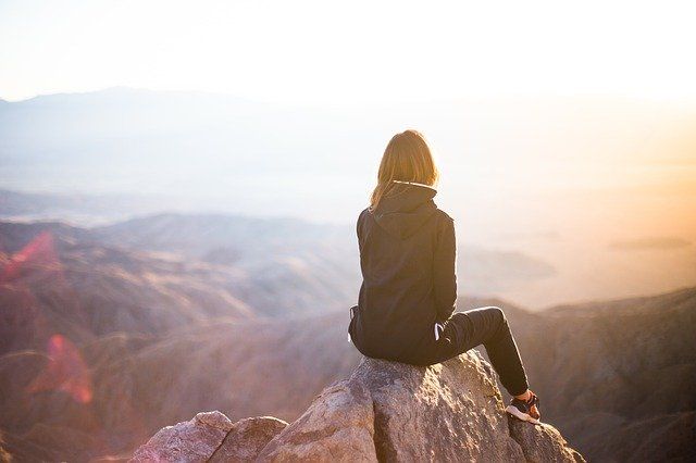 C'est une femme assise sur le sommet d'une montagne.