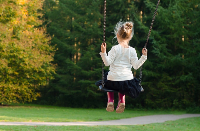 Petite fille qui fait de la balançoire en tutu.