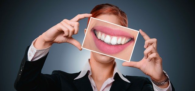 Femme avec photo d'une belle dentition devant le visage