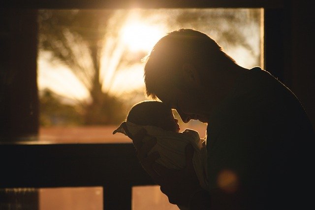 Père qui tient son bébé proche de son visage.