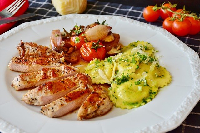 Assiette avec du poulet, des légumes et des ravioles