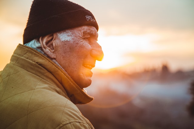Homme âgé souriant en regardant l'horizon.